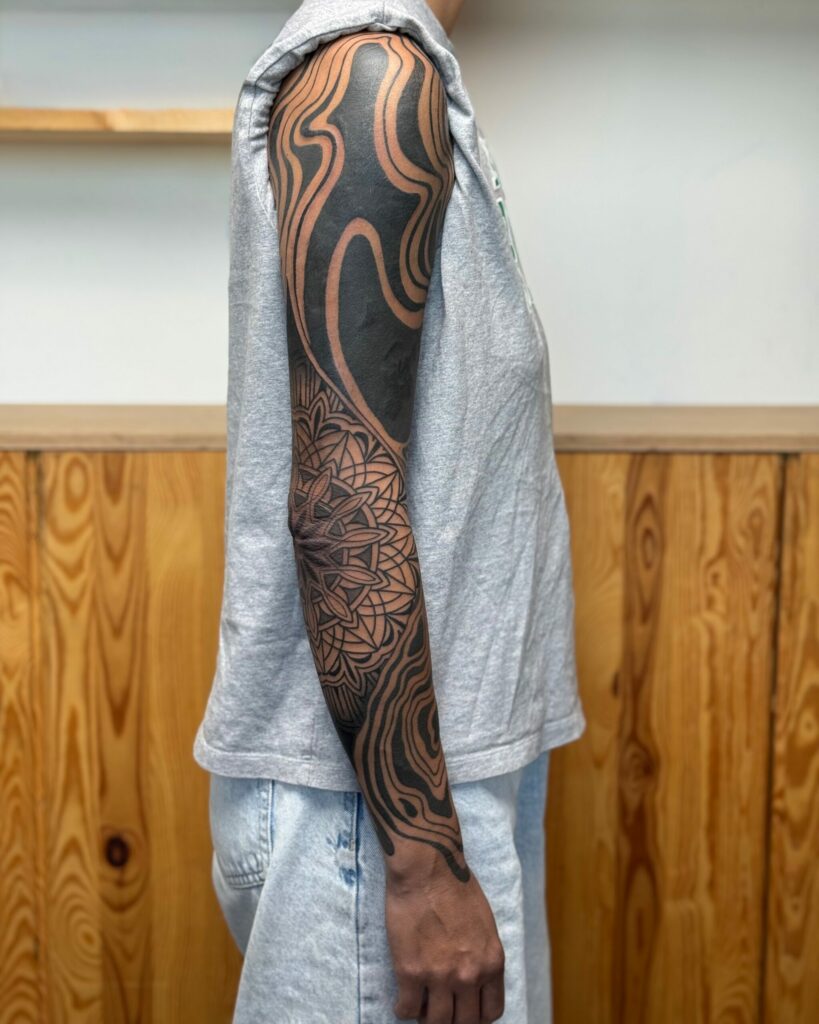 tatouage blackwork Landes sur bras avec composition géométrique à Mimizan-Plage